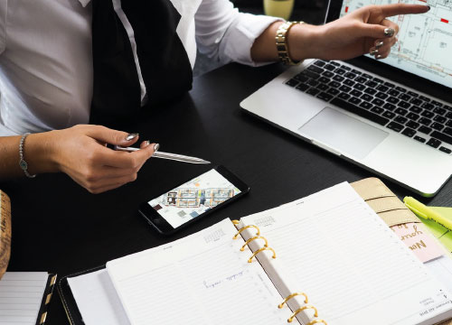 Mulher junto a um computador e smartphone